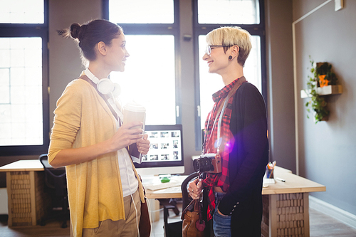 Graphic designers smiling while talking in office