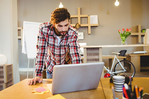 Graphic designer working on laptop at office