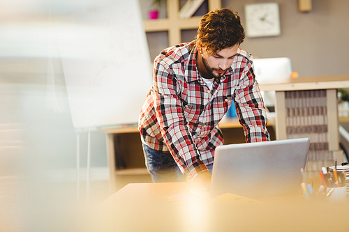 Graphic designer working on laptop at office