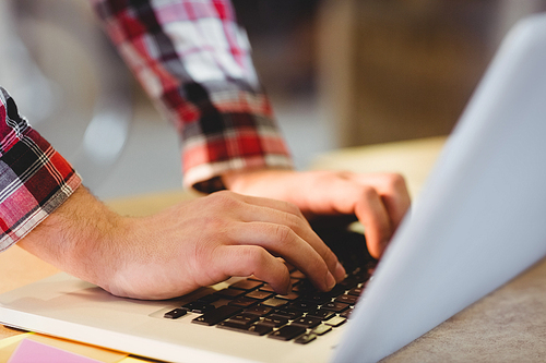 Mans hand using laptop at office