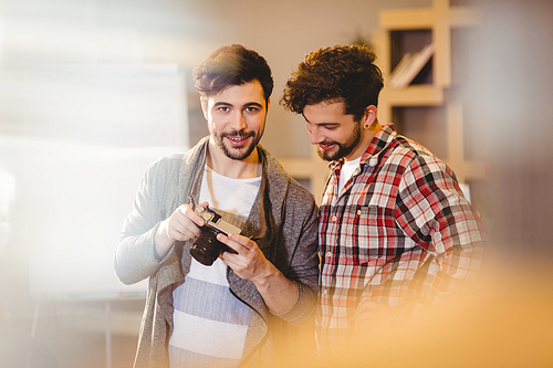 Graphic designer using camera with his coworker in the office