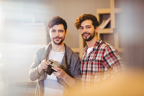 Graphic designer using camera with his coworker in the office