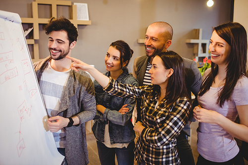 Team of graphic designer discussing chart on white board in the office