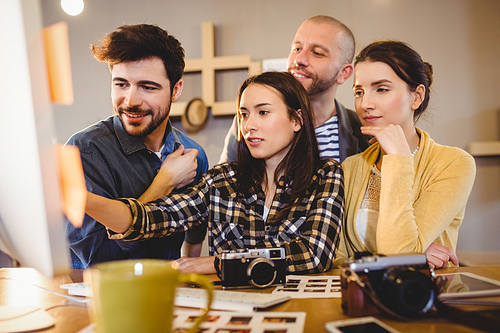 Team of graphic designers working on a computer in office