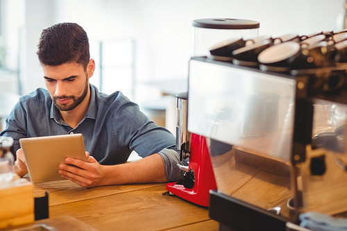 Young man using digital tablet in office cafeteria