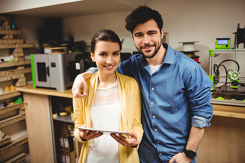 Portrait of graphic designers holding digital tablet in office