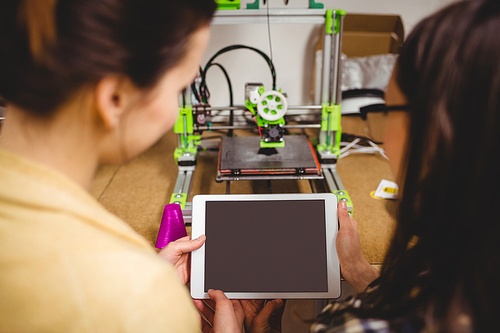 Close-up of graphic designers interacting using digital tablet in office