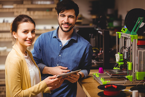 Portrait of graphic designers holding digital tablet in office