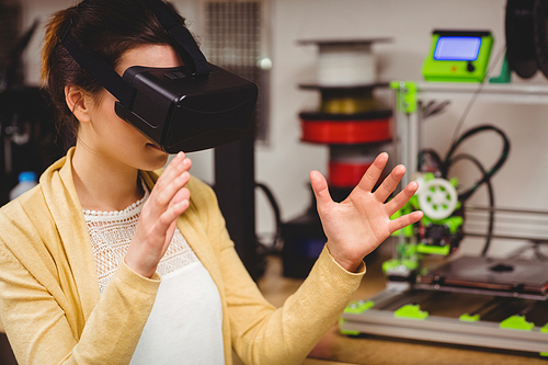 Female graphic designer using the virtual reality headset at office