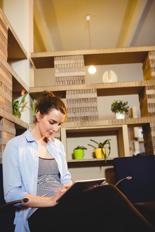 Beautiful young woman using digital tablet at office