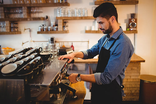 Man taking coffee from espresso machine in office cafeteria