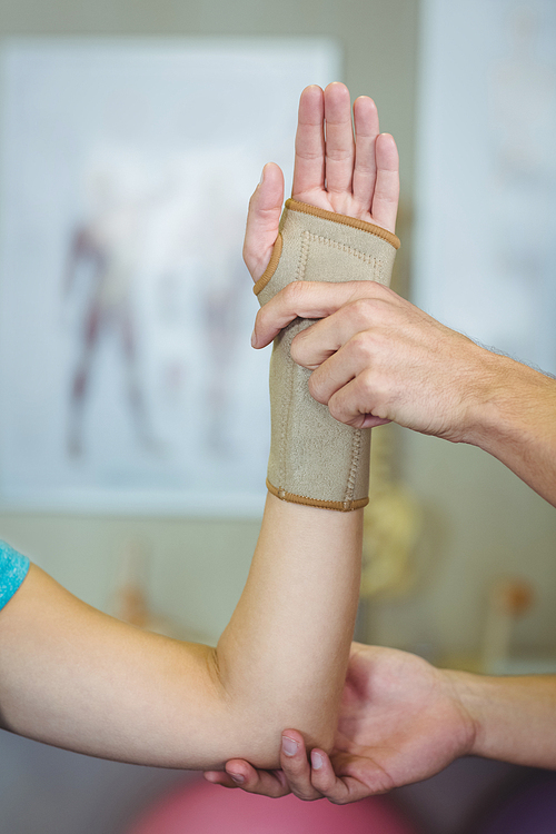 Physiotherapist examining a woman wrist in clinic
