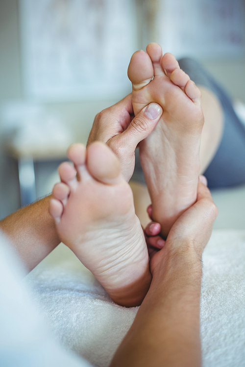 Physiotherapist giving foot massage to a woman in clinic