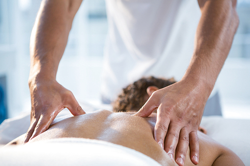 Woman receiving back massage from physiotherapist in clinic