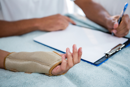 Physiotherapist examining hand of a female patient in clinic