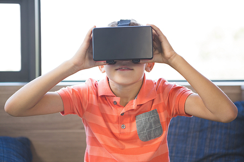 School boy in virtual reality glasses in library at school