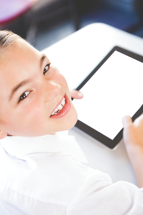 Close-up of schoolkid using digital tablet in classroom at school