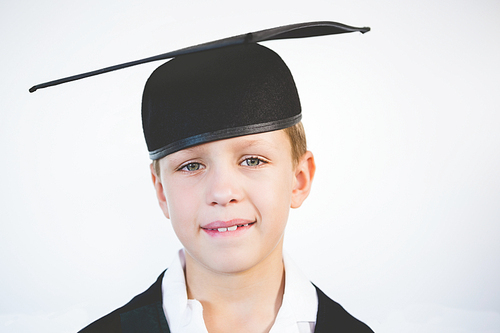 Portrait of schoolkid pretending to be graduate in classroom at school