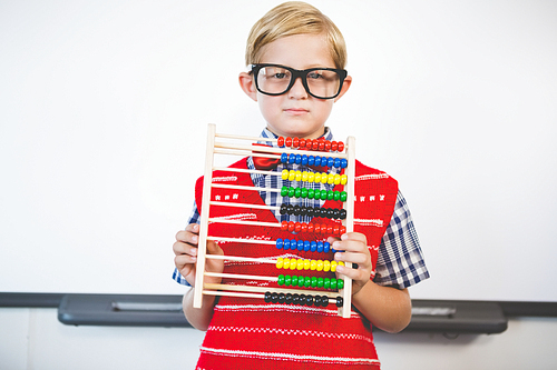 Portrait of schoolkid pretending to be a teacher in classroom at school