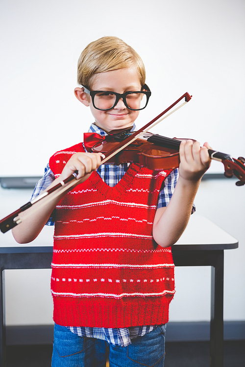 Portrait of schoolkid pretending to be music teacher in classroom at school