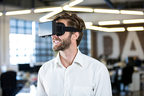 Smilling businessman using virtual reality simulator in office