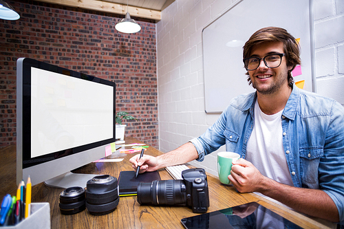 Portrait of smiling male graphic designer working in creative office