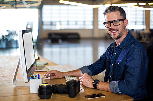 Portrait of smiling man using computer in office