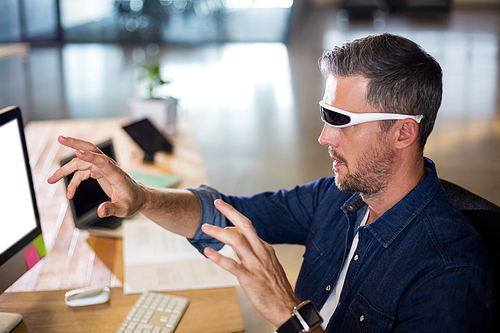Man wearing virtual reality glass by table in office