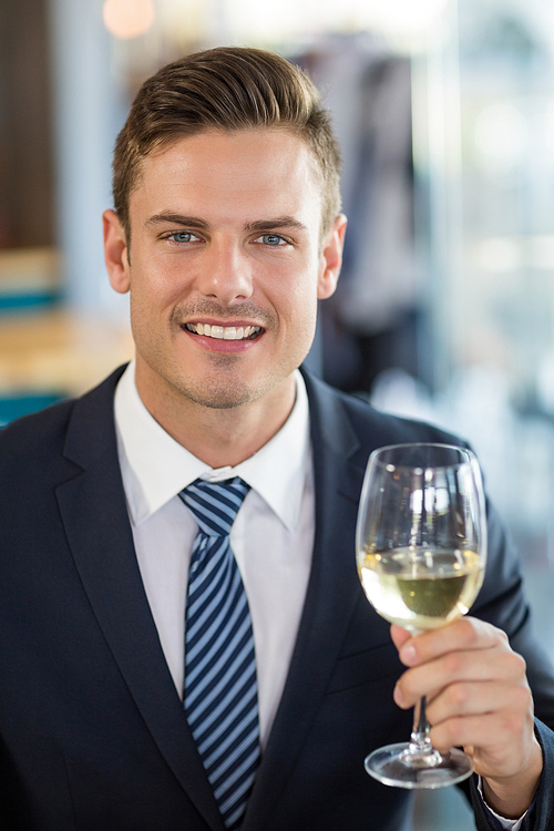 Portrait of smiling businessman holding a beer glass in restaurant
