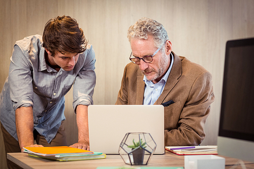 Businessmen working on laptop in office