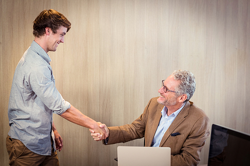 Businessman shaking hands with a coworker in office