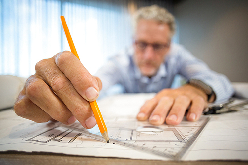 Man working on blueprint in office