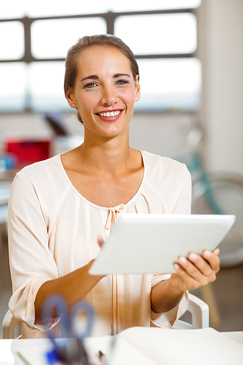 Portrait of smiling business executive using digital tablet in office