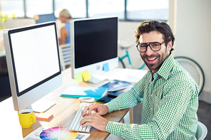 Portrait of smiling graphic designer working on computer in office