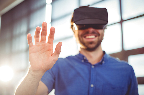 Male business executive using virtual reality headset in office