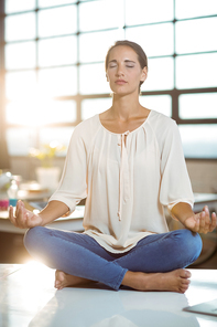 Business executive performing yoga in office