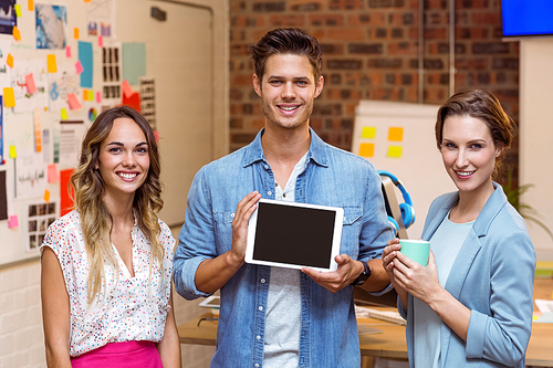 Portrait of business people standing with a digital tablet in office