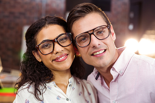 Portrait of couple smiling at workplace in office