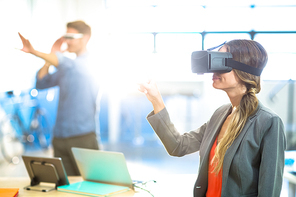 Female graphic designer using the virtual reality headset at office