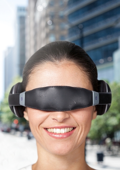 Woman using virtual reality glasses against city buildings in background