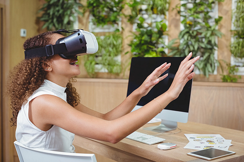 Female business executive using virtual reality headset in office