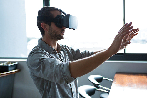 Side view of man using virtual reality headset in creative office