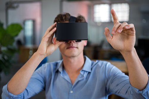 Man using virtual reality headset in creative office