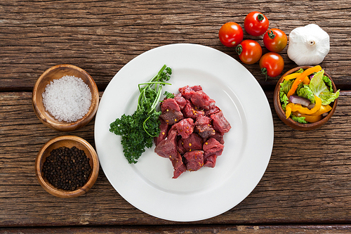 Diced beef and ingredients against black background