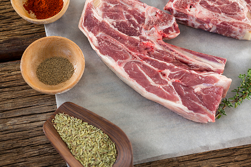 Close-up of raw sirloin steak and ingredients against wooden background