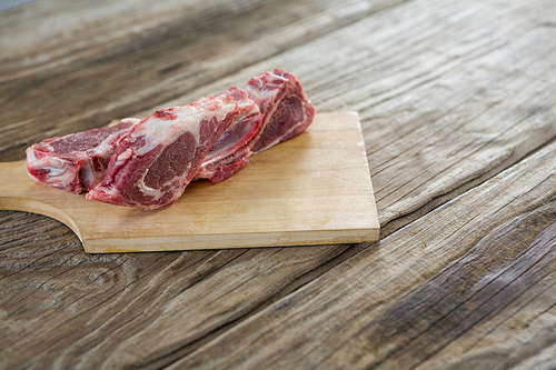Sirloin chop on wooden board against wooden background