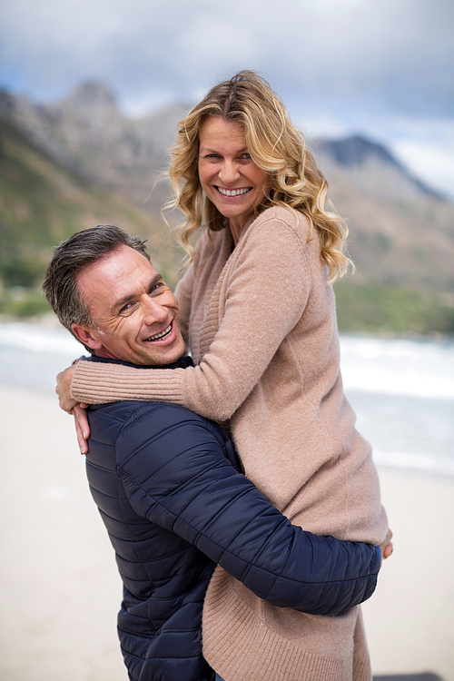 Romantic mature man holding mature woman on beach
