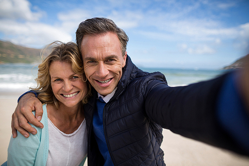 Portrait of mature couple smiling at camera on the beach