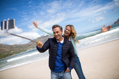 Mature couple taking selfie with selfie stick on the beach
