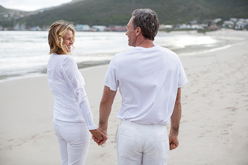 Romantic couple standing with holding hands on the beach